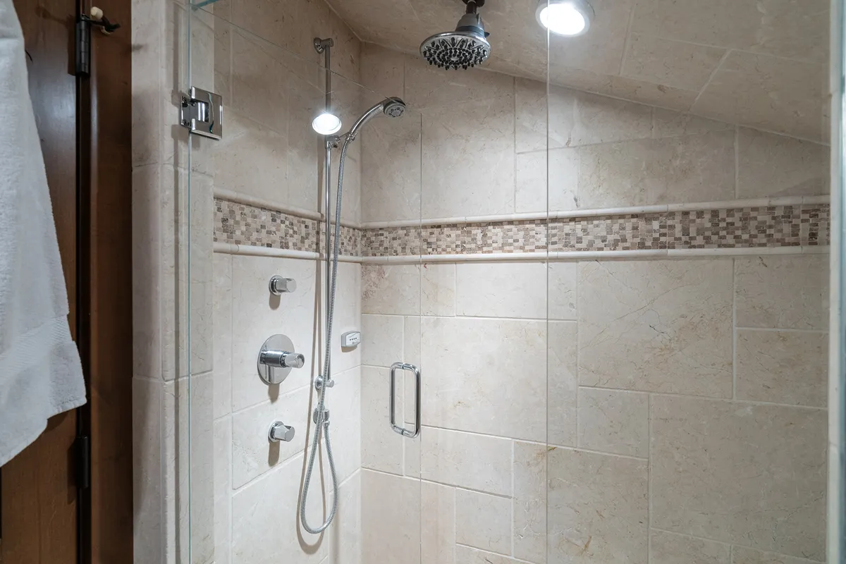 This image features a serene and rejuvenating bathroom space, spotlighting elegant shower fixtures, detailed tile work, and warm lighting. The ambiance is calm and inviting, evoking the feeling of a private retreat for relaxation and self-care.